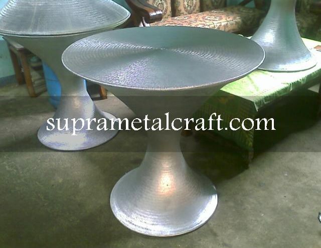 Coffee Table berbahan aluminium ini memiliki bentuk kerucut. Pada permukaan table top menggunakan texture cacahan yg diukir melingkar.